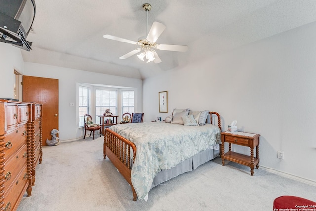 bedroom with ceiling fan, light carpet, vaulted ceiling, and a textured ceiling