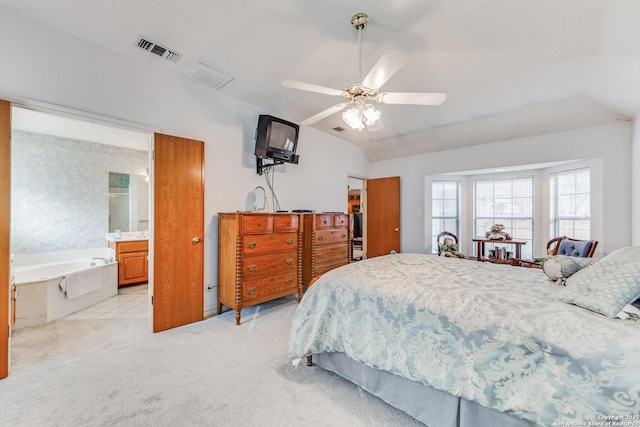 carpeted bedroom featuring ceiling fan, ensuite bath, and vaulted ceiling