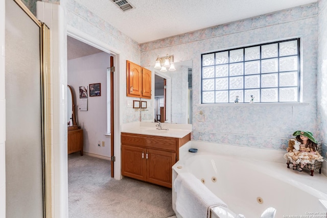 bathroom with a textured ceiling, vanity, and shower with separate bathtub