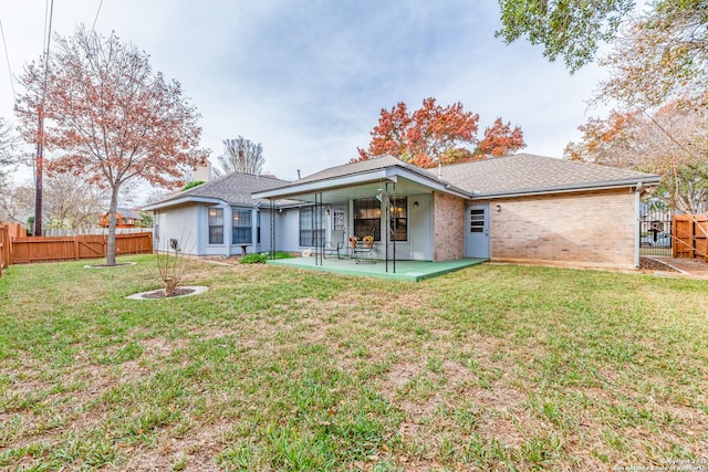 back of property with a patio area and a lawn