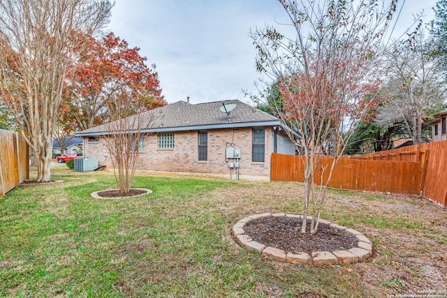 back of property featuring a lawn and central AC