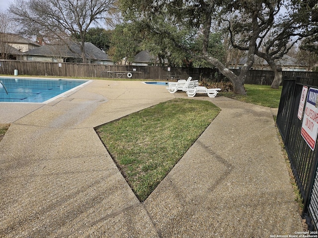 view of pool with a patio and a yard