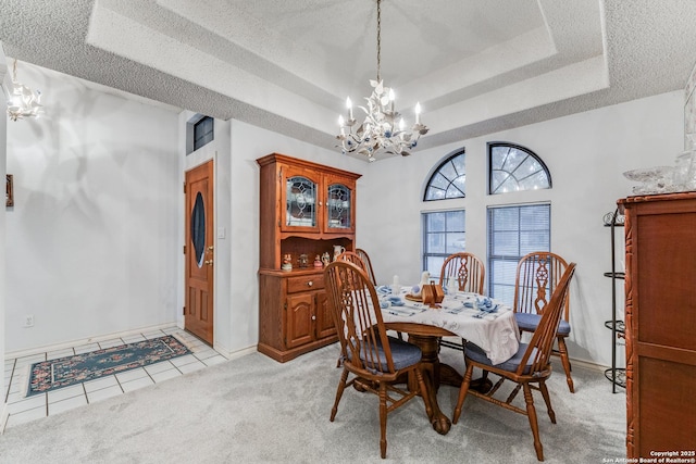 tiled dining space featuring a tray ceiling, a chandelier, and a textured ceiling