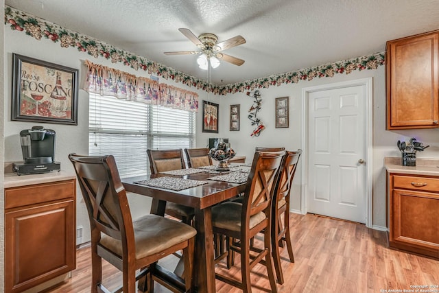 dining space with ceiling fan, a textured ceiling, and light hardwood / wood-style flooring