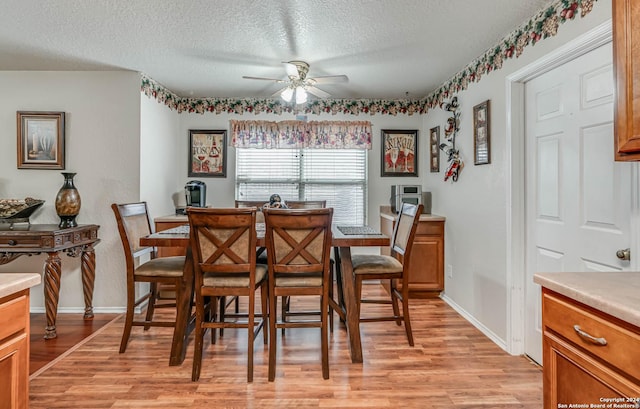 dining area with ceiling fan, a textured ceiling, and light hardwood / wood-style flooring