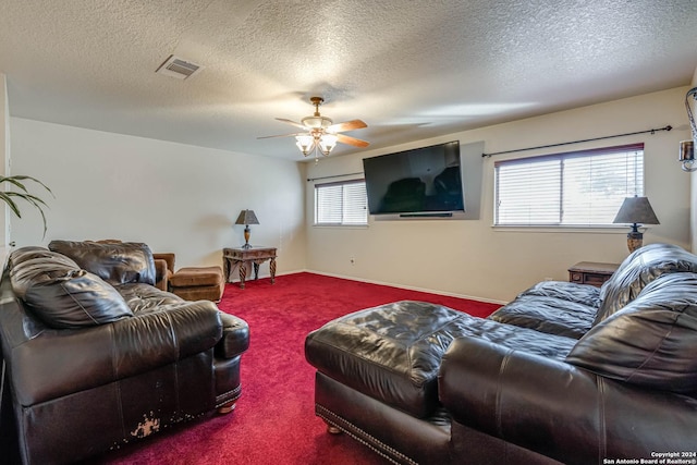 living room featuring carpet floors, ceiling fan, and a textured ceiling