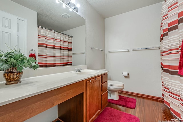 bathroom featuring hardwood / wood-style flooring, a textured ceiling, toilet, and vanity