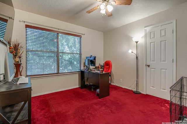 carpeted home office with a textured ceiling and ceiling fan