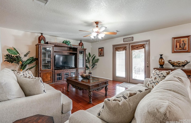 living room with a textured ceiling, ceiling fan, and hardwood / wood-style floors