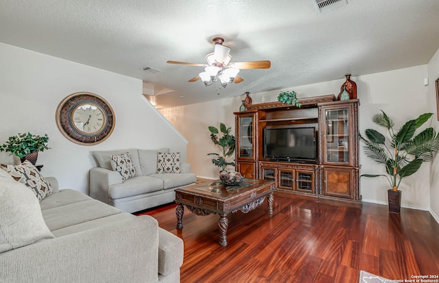 living room with ceiling fan, dark wood-type flooring, and a textured ceiling