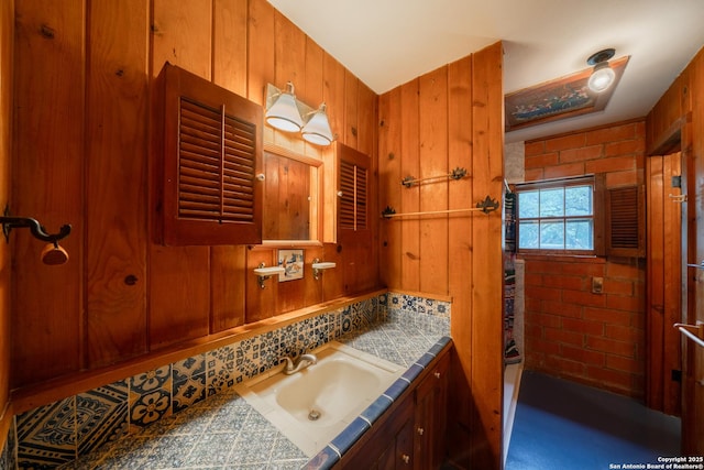 bathroom featuring vanity and wood walls