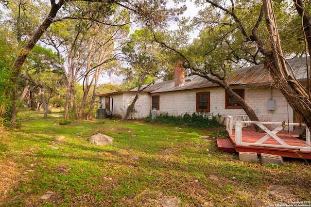 view of yard with central AC and a wooden deck