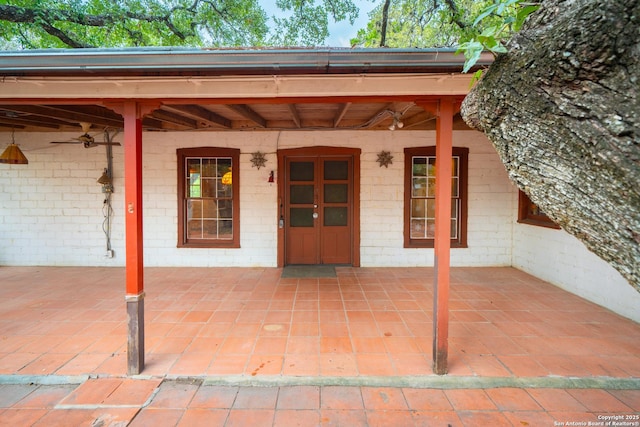 view of exterior entry with a patio area and ceiling fan