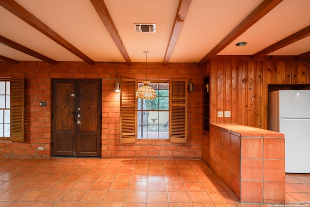 interior space with beam ceiling and wooden walls