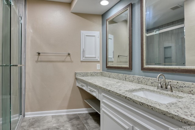 bathroom featuring tile patterned flooring, a shower with door, and vanity