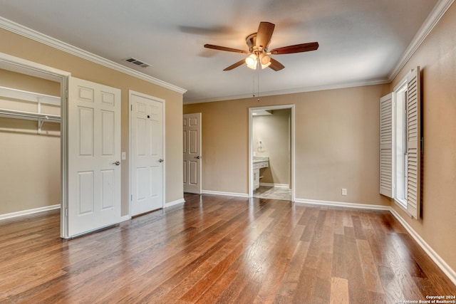 unfurnished bedroom with ceiling fan, ensuite bath, hardwood / wood-style floors, and crown molding