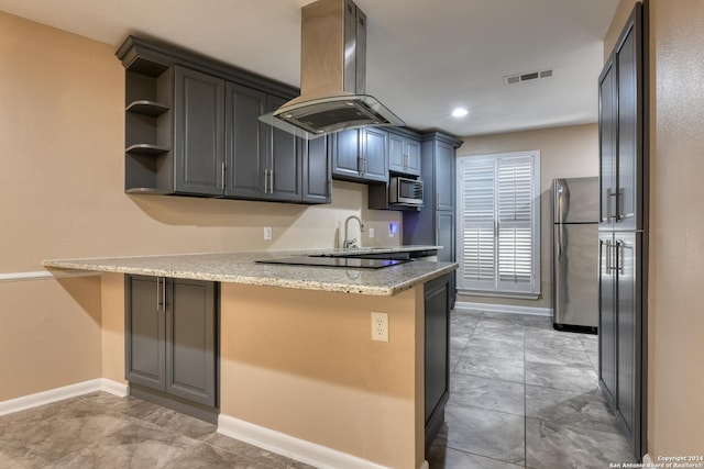 kitchen with island exhaust hood, appliances with stainless steel finishes, kitchen peninsula, and light stone counters