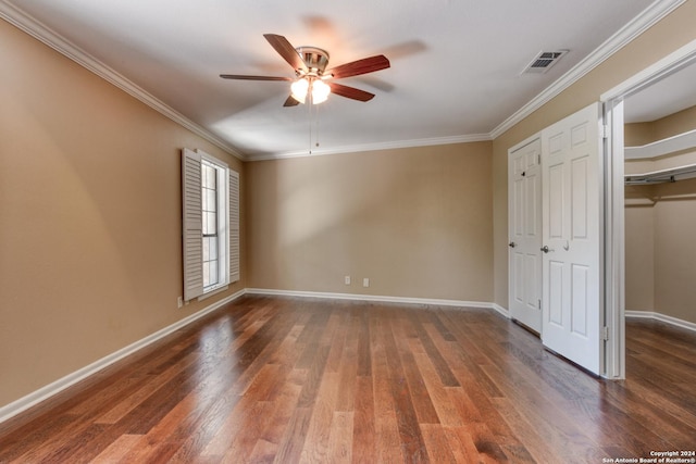 unfurnished bedroom featuring dark wood-type flooring, ceiling fan, and crown molding