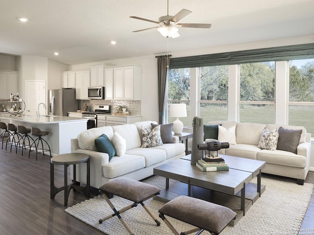 living room with ceiling fan, lofted ceiling, sink, and dark hardwood / wood-style flooring