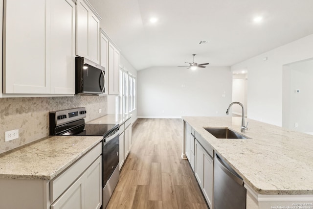 kitchen with white cabinetry, appliances with stainless steel finishes, light stone countertops, and sink