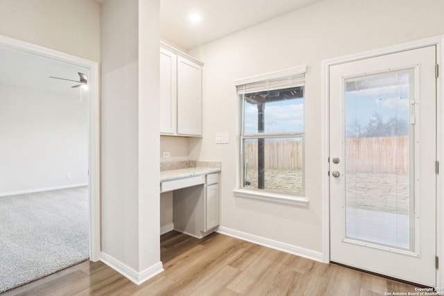 entryway featuring built in desk and light wood-type flooring