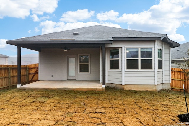 back of property with ceiling fan, a yard, and a patio area