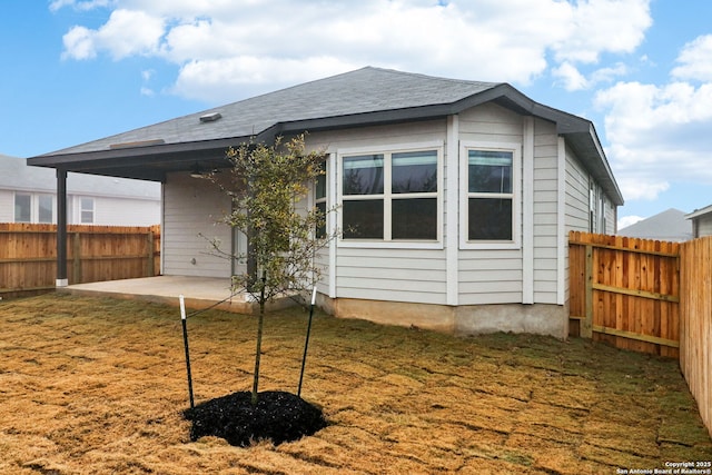 rear view of property featuring a yard and a patio area