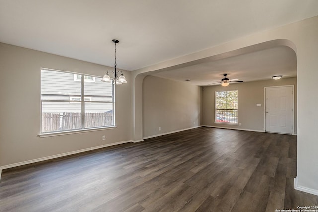 spare room featuring dark hardwood / wood-style flooring and ceiling fan with notable chandelier