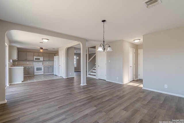 unfurnished living room featuring a chandelier and hardwood / wood-style floors