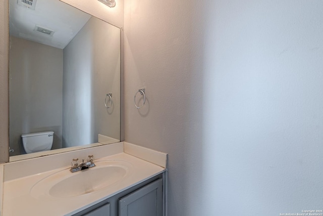 bathroom featuring toilet and vanity