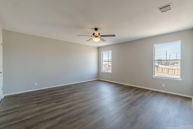 empty room with ceiling fan and dark hardwood / wood-style floors