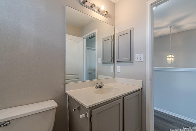 bathroom with hardwood / wood-style floors, toilet, and vanity