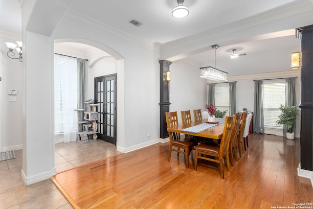 dining area featuring an inviting chandelier, ornamental molding, and hardwood / wood-style flooring