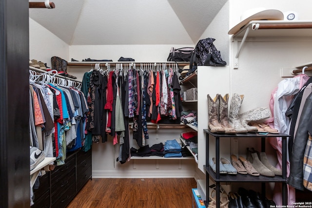 spacious closet featuring dark hardwood / wood-style flooring and lofted ceiling