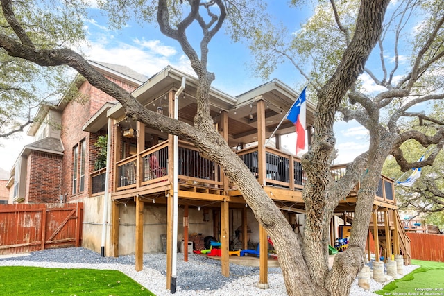 rear view of property with ceiling fan and a deck