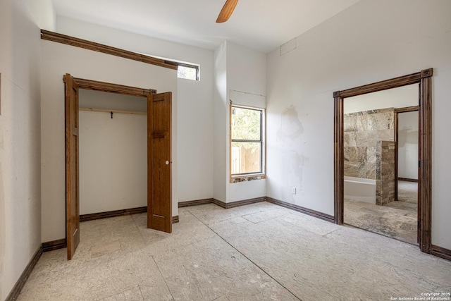 unfurnished bedroom with ceiling fan and connected bathroom