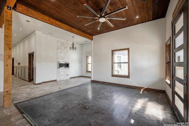 unfurnished living room featuring ceiling fan with notable chandelier and wooden ceiling