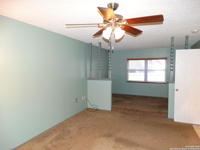 empty room featuring ceiling fan, a textured ceiling, and carpet flooring