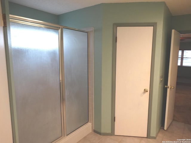 bathroom featuring an enclosed shower and tile patterned flooring