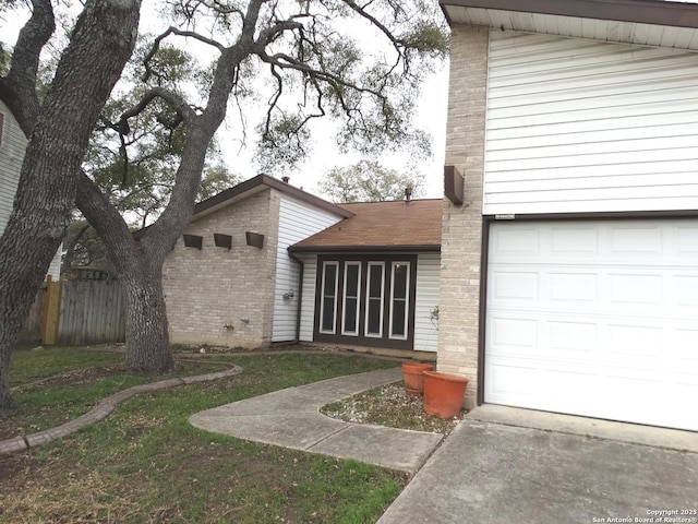 entrance to property with a garage and a yard