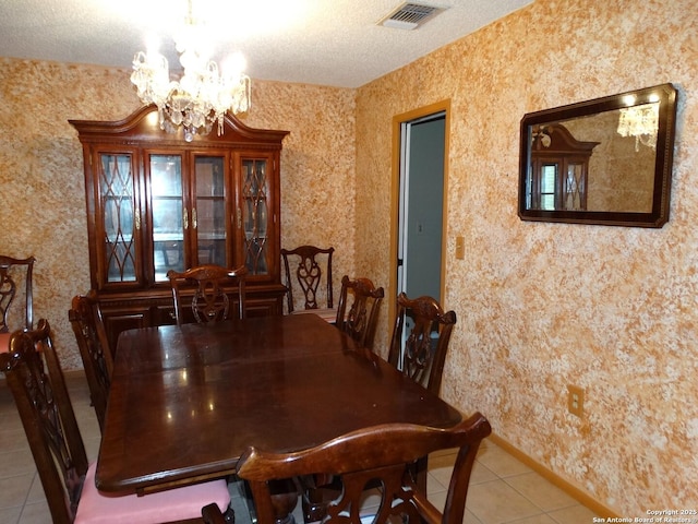 tiled dining space featuring a textured ceiling and a chandelier