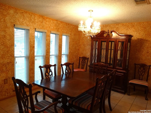 dining space featuring plenty of natural light, a textured ceiling, light tile patterned floors, and an inviting chandelier