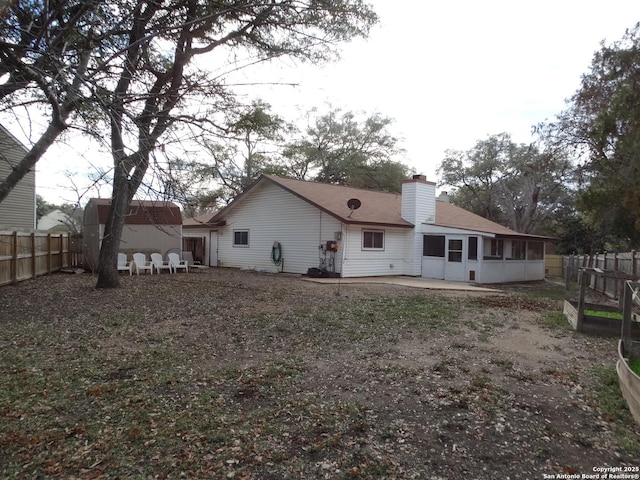 rear view of house featuring a sunroom and a patio