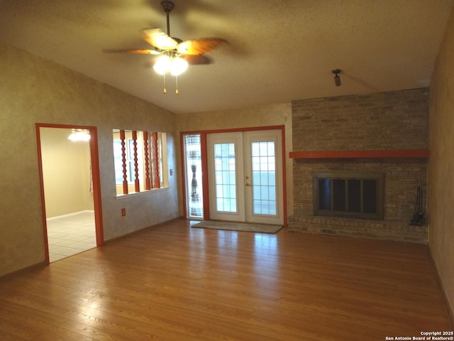 unfurnished living room with ceiling fan, wood-type flooring, french doors, and vaulted ceiling