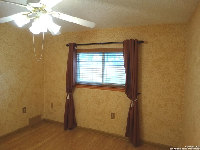 unfurnished room with ceiling fan and wood-type flooring