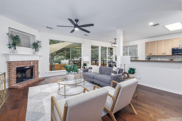 living room with ceiling fan, dark hardwood / wood-style floors, and a fireplace