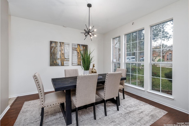 dining area with dark wood-type flooring and a chandelier