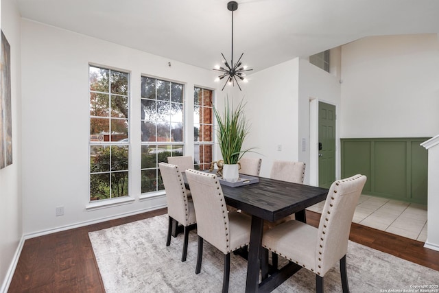 dining area featuring wood-type flooring and an inviting chandelier