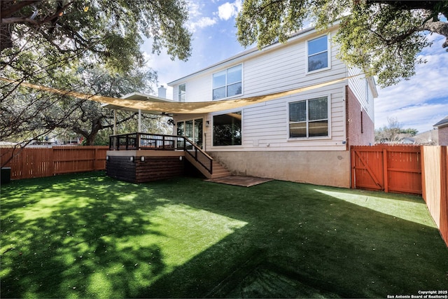 rear view of property featuring a lawn and a deck