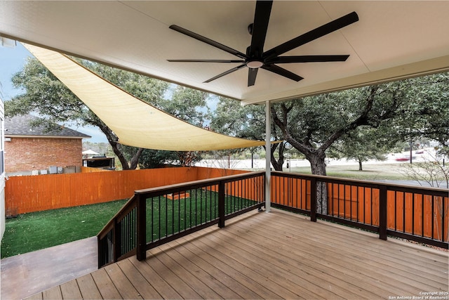 wooden terrace featuring ceiling fan and a lawn